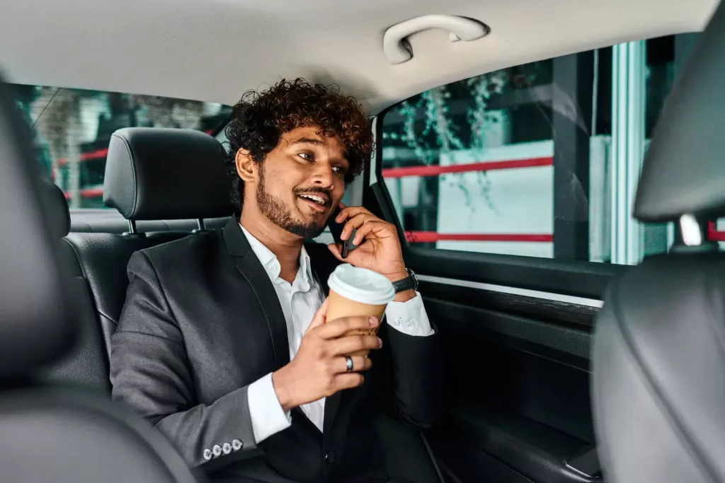 curly-haired-businessman-discusing in vehicle